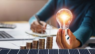 b_385_225_16777215_0_0_images_news_2025_businesswoman-holding-light-bulb-with-turbine-coins-solar-panel-concept-saving-energy-finance-accounting.jpg
